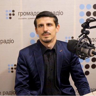 Між символами свастики, серпа та молота.